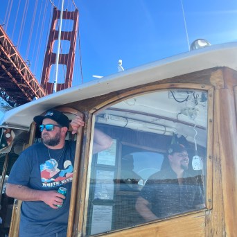 Wine Therapy crew member at the helm with the Golden Gate Bridge, San Francisco Bay cruise