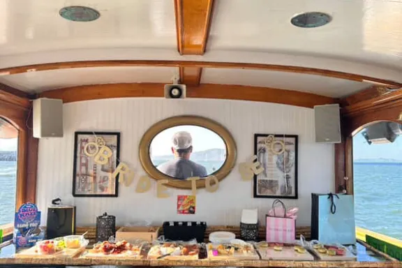 Private charter catering spread aboard Wine Therapy with bachelorette party decorations, San Francisco Bay